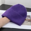 Dettaglio del cappello in maglia viola scuro che mostra la morbida trama in finta pelliccia - Viola scuro