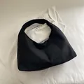 Minimalist black matte crescent tote bag in suede texture with integrated wide shoulder strap - Black