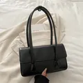 Schwarze Schultertasche aus Ölleder mit eleganter Klappe und schmalen Doppelgriffen im Retro-Stil - Schwarz