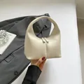 Minimalist cream white leather hobo handbag with dual zipper closure and vertical stitching - White