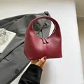 Elegant burgundy leather handbag with semi-circular silhouette and vertical stitching - Red
