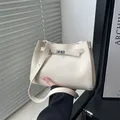 Minimalistische cremeweiße Tragetasche mit silbernem Drehverschluss und Premium-PU-Ledertextur - Weiß