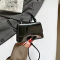 Mini borsa a mano in vernice nera lucida con patta ondulata e tracolla sottile - Nero