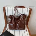 Borsa tote marrone scuro lucida con tracolla a catena e dettagli con nappine - Marrone