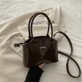 Dark brown patent leather handbag with metal FASHION logo and detachable strap - Brown