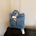 Blue denim tote bag with dual front pockets and a white plush cloud charm accessory - With Cloud Pendant / Light Blue