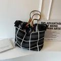 Gestreifte Stricktasche mit schwarz-weißen Fransen und braunen Ledergriffen - Schwarz