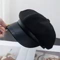 Detail of black octagonal newsboy hat featuring textured PU leather brim and fabric stitching - Black