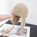 Detailed knit texture and earflaps of a beige winter trapper hat with braided straps - M (56-58cm) / Light Khaki