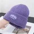 Nahaufnahme der lila Strickmütze mit HIOW Design-Label und gerippter Strickstruktur - Einheitsgröße / Lila