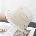 Detail of beige bucket hat showing faux fur trim and adjustable side drawstring toggle - Adjustable / Beige