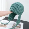 Detailed view of sage green thick-knit trapper hat with long earflaps for winter warmth - M (56-58cm) / Green