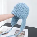 Detailed view of light blue thick knit winter trapper hat with braided ties and earflaps - M (56-58cm) / Sky Blue
