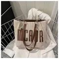 Schicke cremefarbene Strohtasche mit braunem MCAIR Leder-Logo und Metallkette - Kaffeebraun