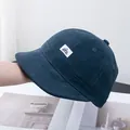 Vue détaillée du bonnet en velours côtelé bleu foncé avec écusson brodé D.Y.X - Réglable / Bleu marine