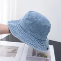 Détail d'un bob en denim bleu clair avec œillets métalliques et coutures renforcées au bord - Réglable / Bleu clair