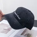 Vista detallada de gorra de mezclilla gris con bordado blanco Pamela Raina en el lateral - Ajustable / Negro