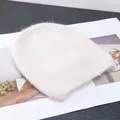 Dettaglio della morbida pelliccia di coniglio sul berretto in maglia panna - Beige