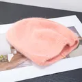 Dettaglio ravvicinato di un berretto in maglia rosa con morbida trama in peluche - Rosa Arancio
