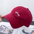 Dettaglio ravvicinato del ricamo 'Funny' bianco su cappello da baseball in cotone rosso - Regolabile / Borgogna