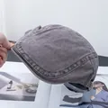 Detail van de verstelbare metalen gesp en stiksels op de grijze vintage baretmuts - Verstelbaar / koffiekleur