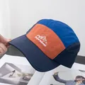 Detalle de gorra camper multicolor con bordado de montaña y tela de nailon duradera - Ajustable / Azul Marino Patchwork Naranja