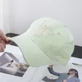 Close-up of light green baseball cap featuring pink ribbon bow embroidery details - Adjustable / Green