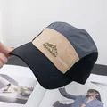 Detalle del bordado de montaña y texto en una gorra de béisbol de tres colores de moda - Ajustable / Negro Patchwork Caqui