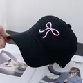 Close-up of pink bow embroidery on a black cotton baseball cap with high texture - Adjustable / Black