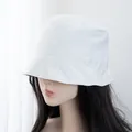 Close-up of a white cotton bucket hat with decorative stitching on a female model - Adjustable / White