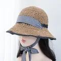 Detail of hand-woven straw hat featuring black wavy edges and plaid ribbon ties - Adjustable / Khaki Black Hat Black White Plaid Ribbon