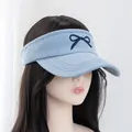 Detail of embroidered navy bow on light blue denim open top visor hat with curved stitching - Adjustable / Light Blue