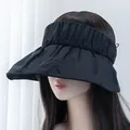 Detail view of the wide pleated brim and elastic headband of the black sun visor hat - Adjustable / Black