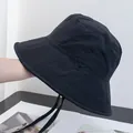 Detail of a black bucket hat showing triangular stitching and adjustable chin strap - Adjustable / Black