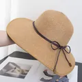 Close-up of beige woven straw sun hat with brown drawstring bow and wooden bead details - Adjustable / Khaki