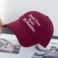 Detailed close-up of white embroidery text on a premium burgundy cotton baseball cap - Adjustable / Burgundy
