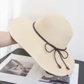 Detail of cream straw sun hat featuring dark brown cord bow and wooden bead accents - Adjustable / Beige
