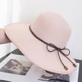 Detail of light pink straw hat featuring fine weave and brown leather cord with wood bead - Adjustable / Pink