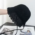 Dettaglio cappello a secchiello in paglia nera all'uncinetto con pizzo e lacci estivi - M / Nero