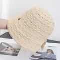 Nahaufnahme der geflochtenen Strohhutstruktur mit einem runden Metall-Logo an der Seite - M (56-58cm) / Beige