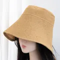 Close-up of a khaki woven straw hat with a wide brim showing fine texture on a model - M (56-58cm) / Khaki