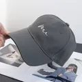 Detailed view of hand-held dark grey baseball cap with minimalist white me embroidery - Adjustable / Dark Gray