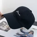Detail van wit 'me' borduursel op een zwarte katoenen twill baseballpet voor sport - Verstelbaar / Zwart