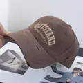 Close-up of brown vintage distressed cotton baseball cap with embroidered lettering detail - Adjustable / Coffee