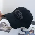 Detail of distressed brim and embroidered OUTSTAND lettering on black cotton baseball cap - Adjustable / Black