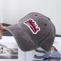 Detalle de gorra de béisbol lavada vintage con parche bordado en tela de algodón premium - Ajustable / Café