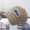 Detalle macro de una gorra de béisbol de algodón lavado caqui con parche vintage bordado - Ajustable / Caqui