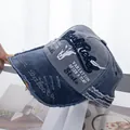 Detail der BlackRebel-Stickerei und der ausgefransten Kanten der grauen Denim-Kappe - Grau Hut Marineblaue Krempe