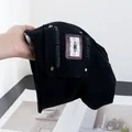 Close-up of black retro bucket hat with tape patch, silver studs and letter embroidery - M (56-58cm) / Black