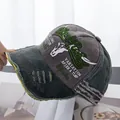 Detail of distressed baseball cap with Black Rebel embroidery and frayed brim texture - Coffee Hat Army Green Brim